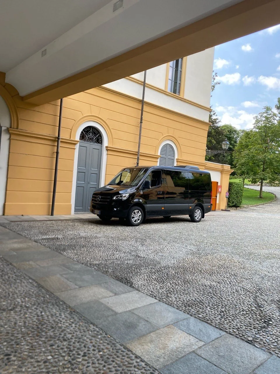 Minivan Mercedes Sprinter nero frontale, villa italiana Minivan Mercedes Sprinter nero frontale, villa italiana